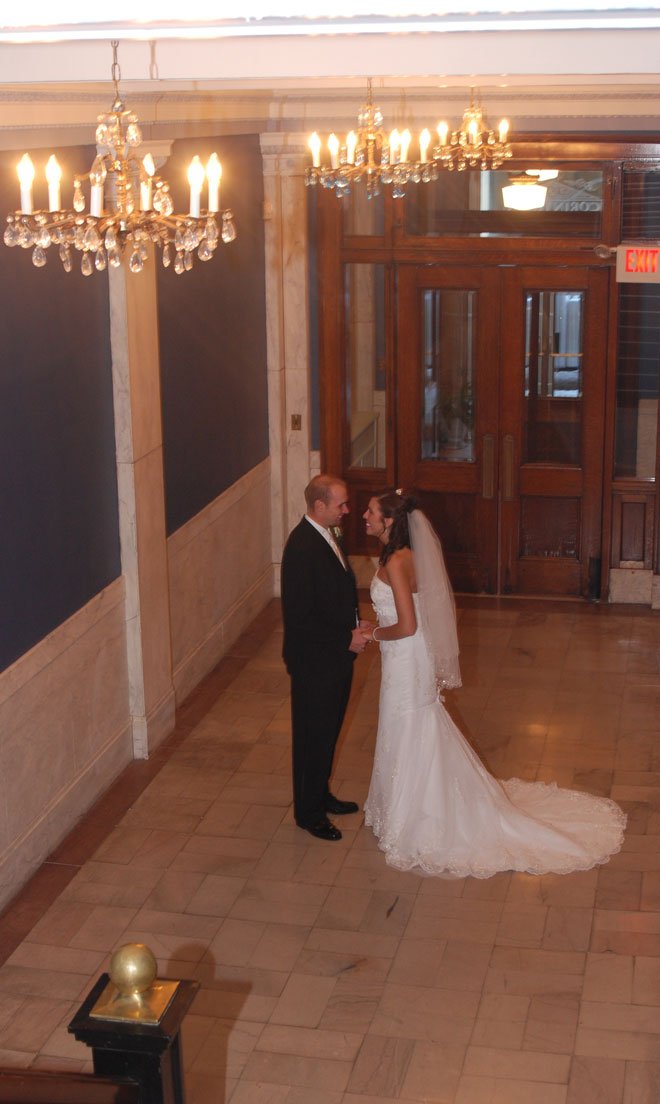 Bride and Groom embrace in blue marble entrance at The Corinthian Event Center.