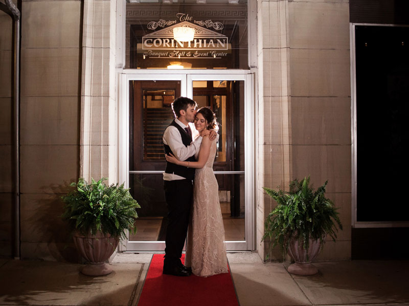 Bride and Groom embrace at marble entrance at The Corinthian Event Center.