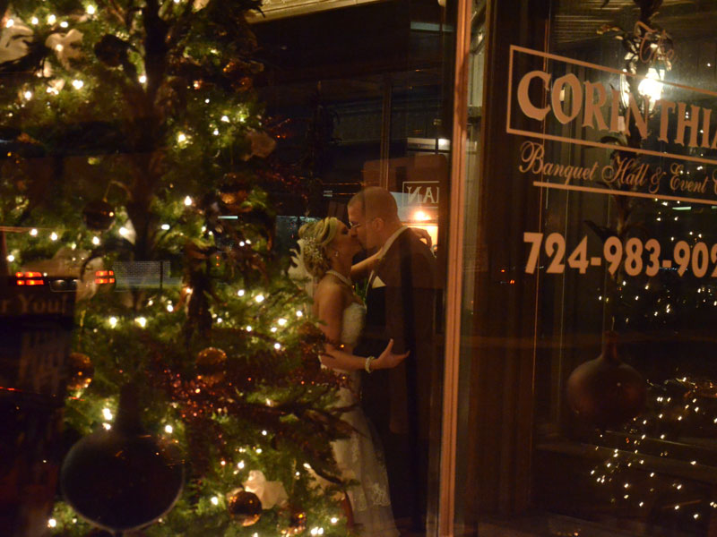 Bride and Groom kiss in lobby near christmass tree at winter wedding at The Corinthian Event Center.