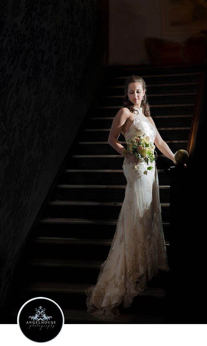 Bride in the spotlight on stairs of blue marble entrance at The Corinthian Event Center.