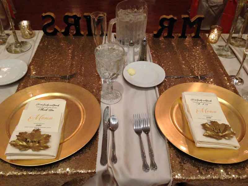 Gold place place settings at The Corinthian Event Center.