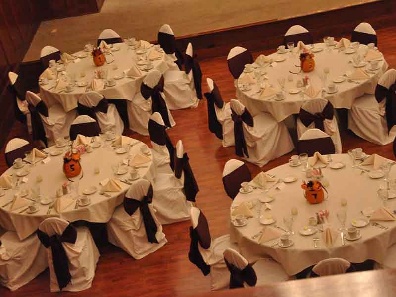 Grand Ballroom setup in black and white theme with chair covers, halloween decor centerpieces, and white plate place settings at The Corinthian Event Center.